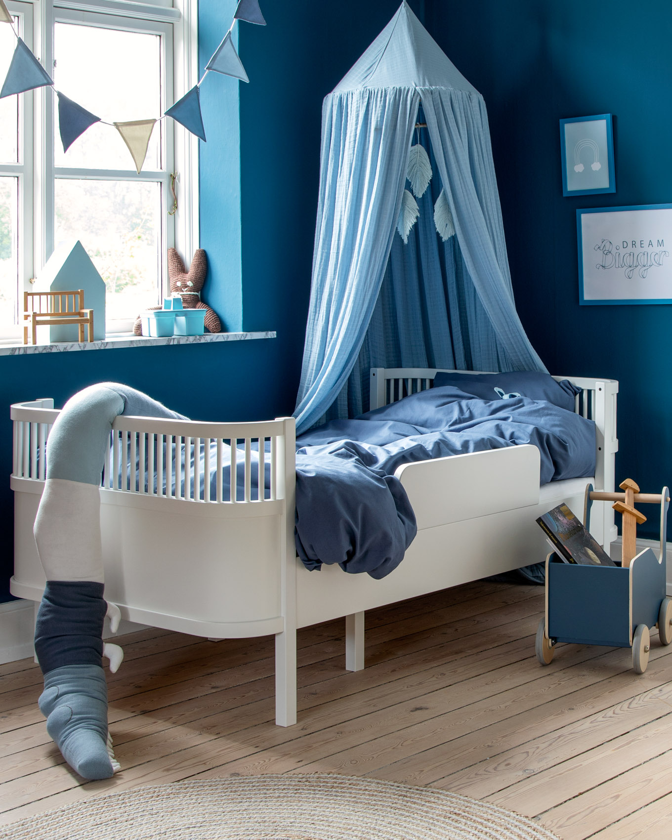 Kinderzimmer in Blau von Sebra mit Kinderbett, blauer Wand und Deko