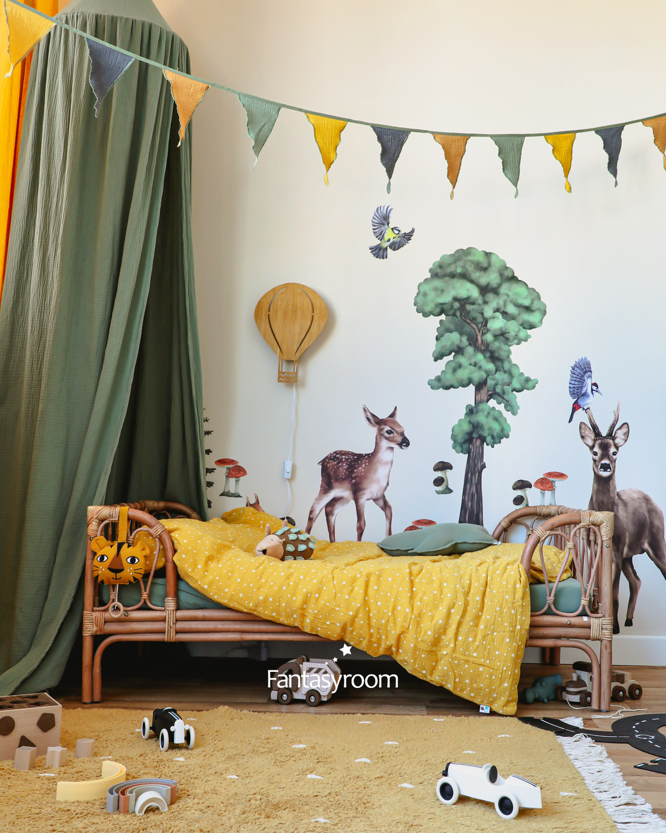 Kinderzimmer mit Waldtieren, gelber Bettwäsche und grünem Betthimmel