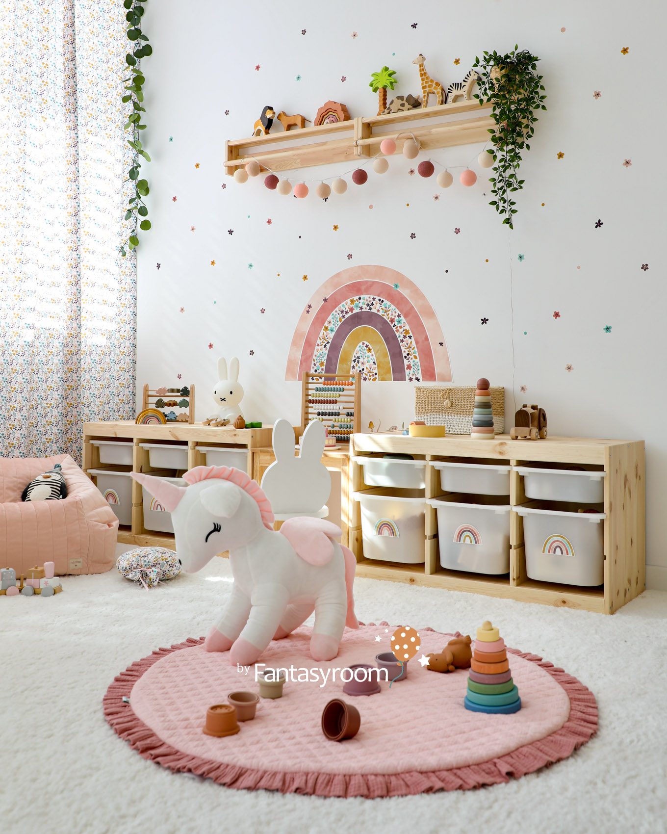 Spielzimmer mit Holzregal, Regenbogen Wandtattoo, Kuscheltieren und rosa Spielzeug