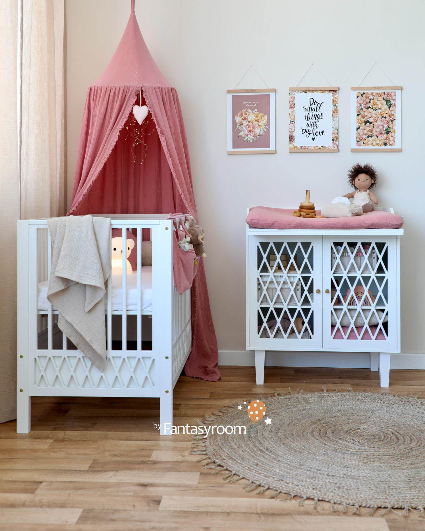 Babyzimmer in Naturtönen mit weißen Möbeln und altrosa Textilien